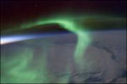 Photograph of green aurora and sunset.